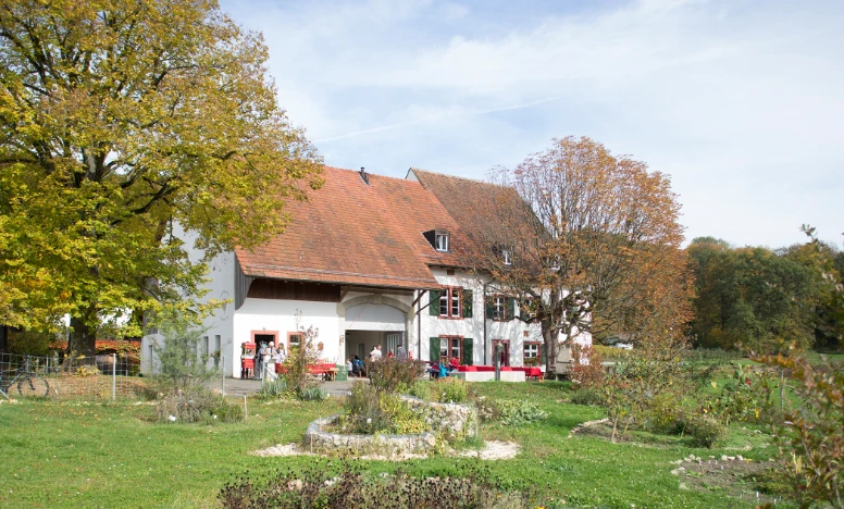 Spittelof Garten Das Foto zeigt einen grossen Garten mit einem Haus und Bäumen.