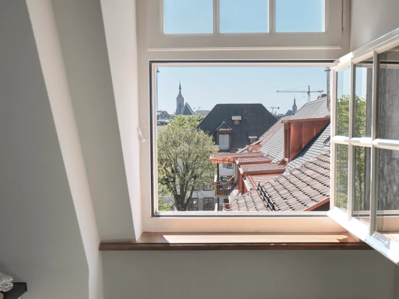 Ausblick aus einem Fenster auf die Dächer der Nachbarschaft