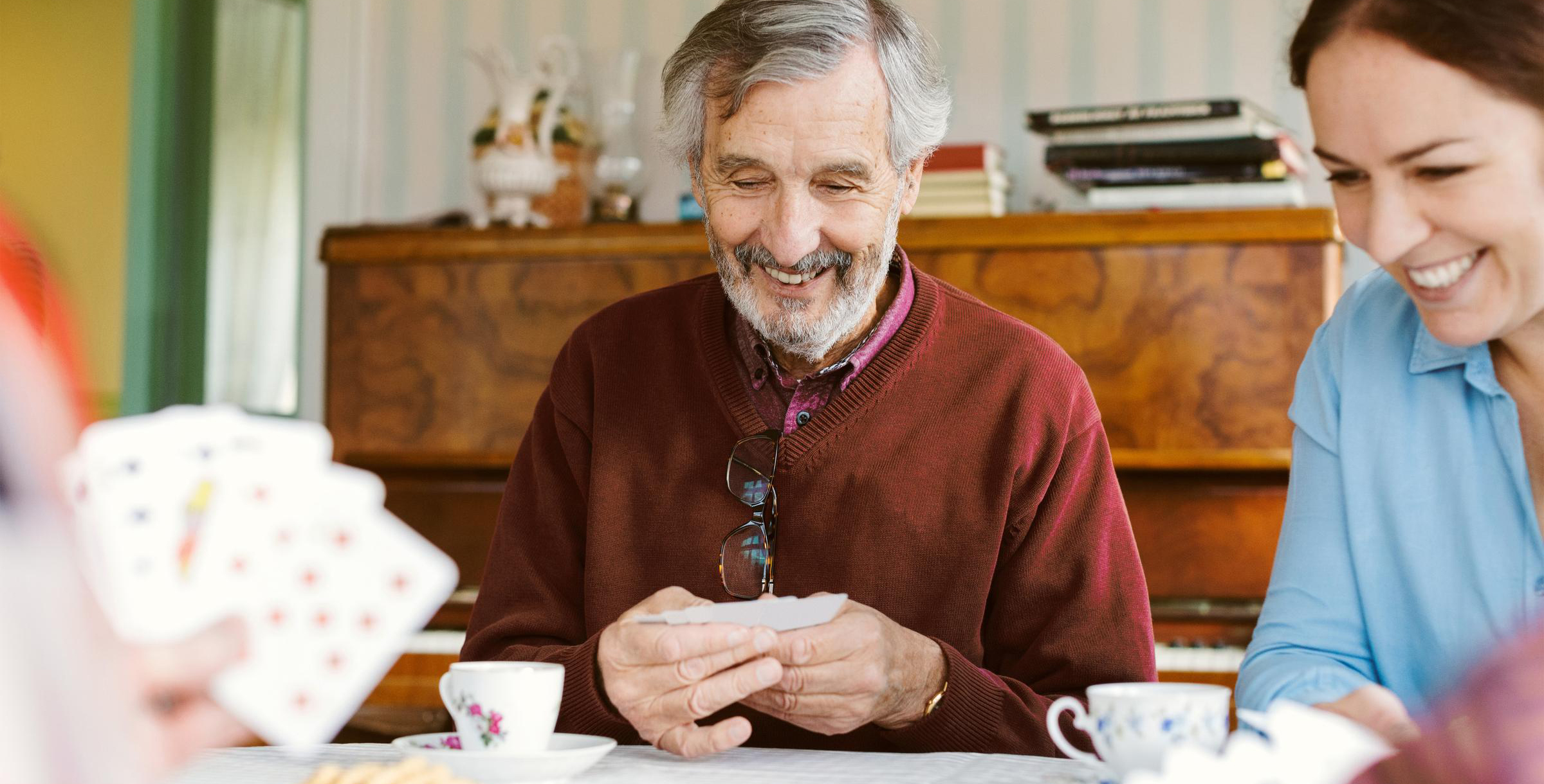 Senior mit seiner Familie am Karten spielen