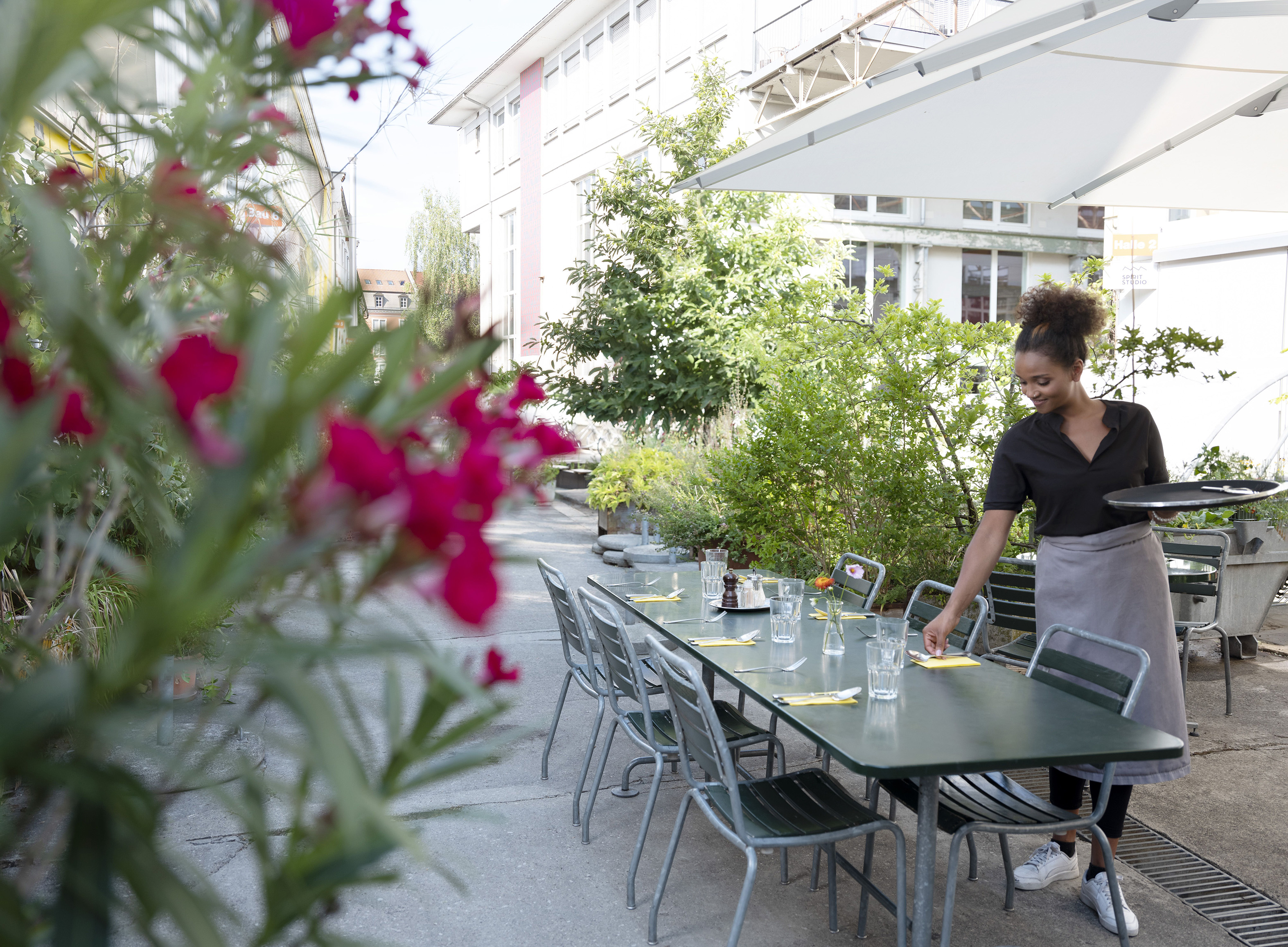 Restaurationsfachfrau am Tisch decken 