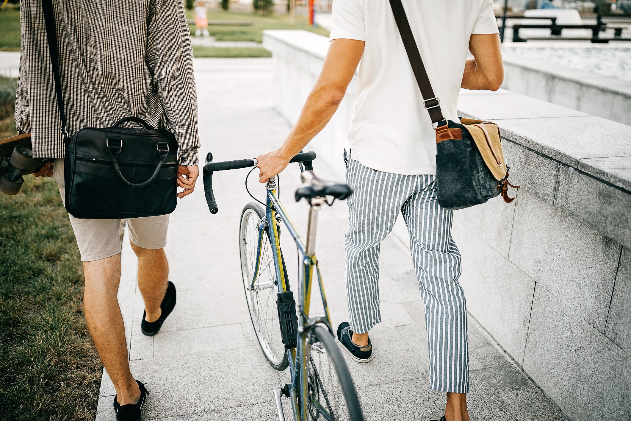 Zwei Mitarbeiter am spazieren mit einem Fahrrad und einem Skateboard