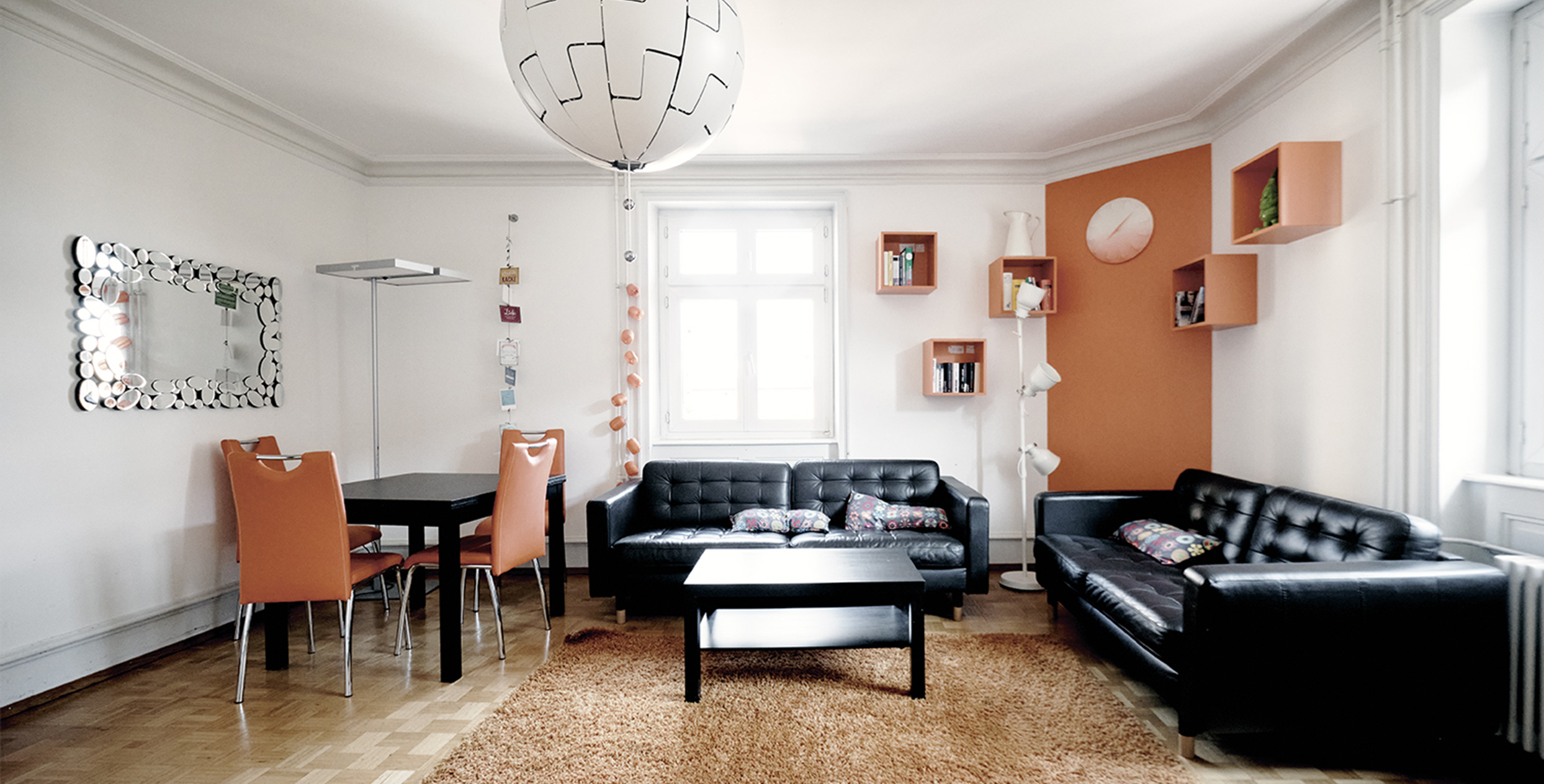 Ein helles Wohnzimmer mit orangen Akzenten