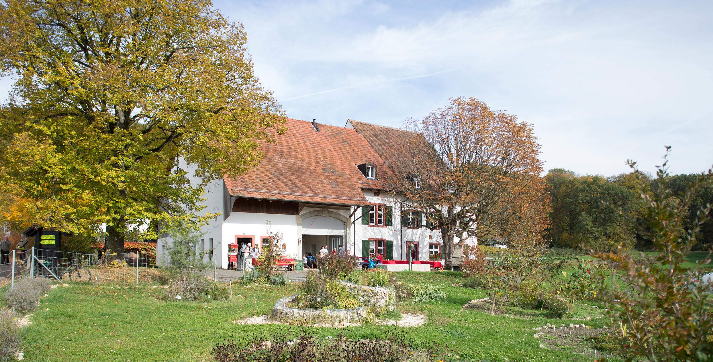 Das Foto zeigt einen grossen Garten mit einem Haus und Bäumen.