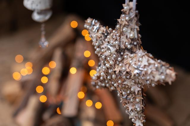 Eine Nahaufnahme von einem sternförmigen Christbaumschmuck im Vordergrund, der Hintergrund ist verschwommen