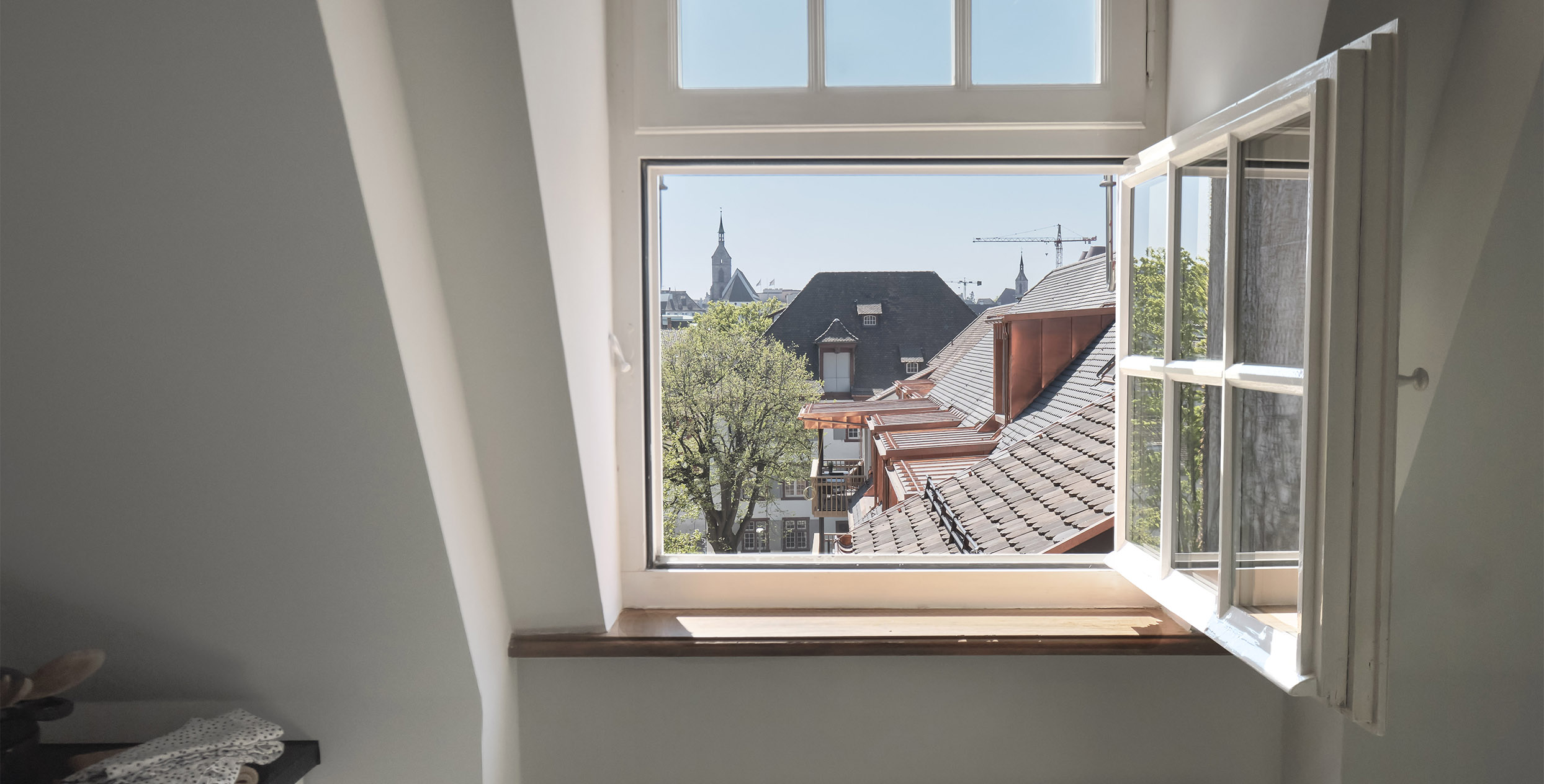 Ausblick aus einem Fenster auf die Dächer der Nachbarschaft