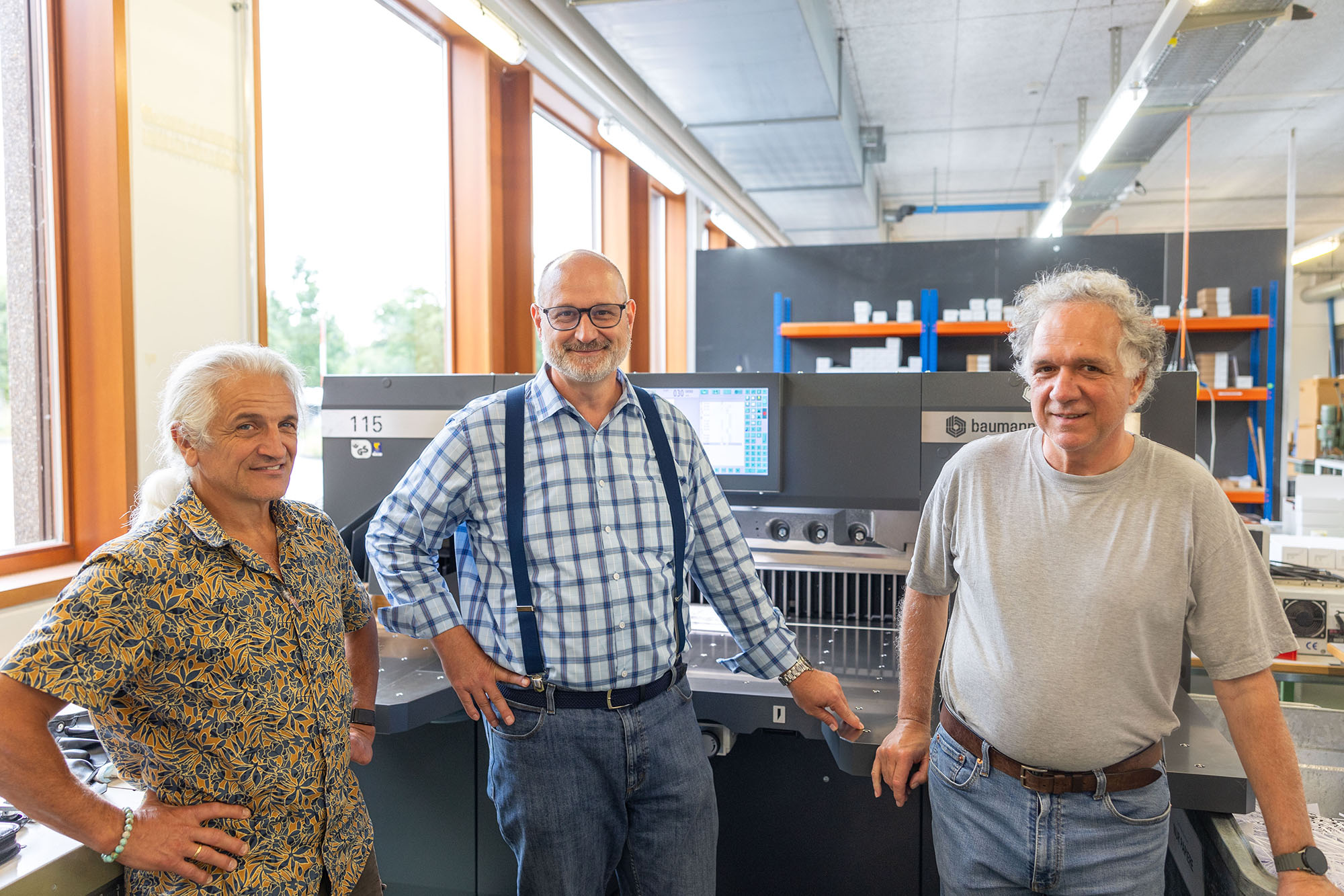 Der Leiter der BSB Medien, Marc Ingold zusammen Gérard Staiblé und Beat Rauber im Weiterverarbeitungsraum vor der neuen Maschine.