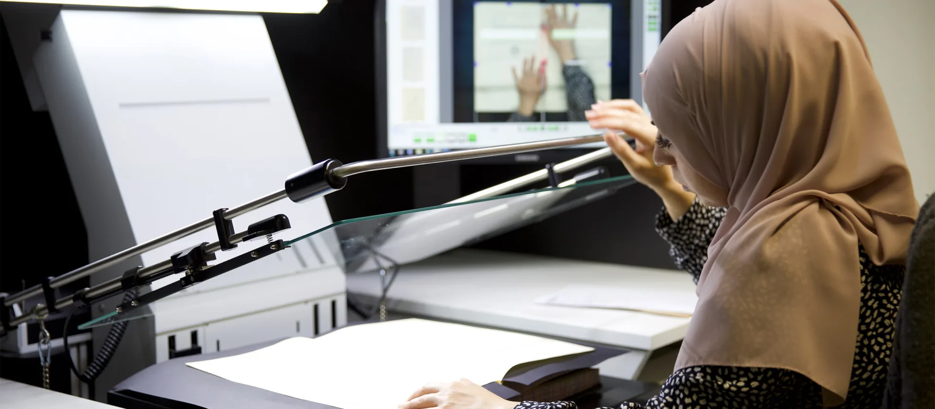 Eine Person digitalisiert ein Buch.