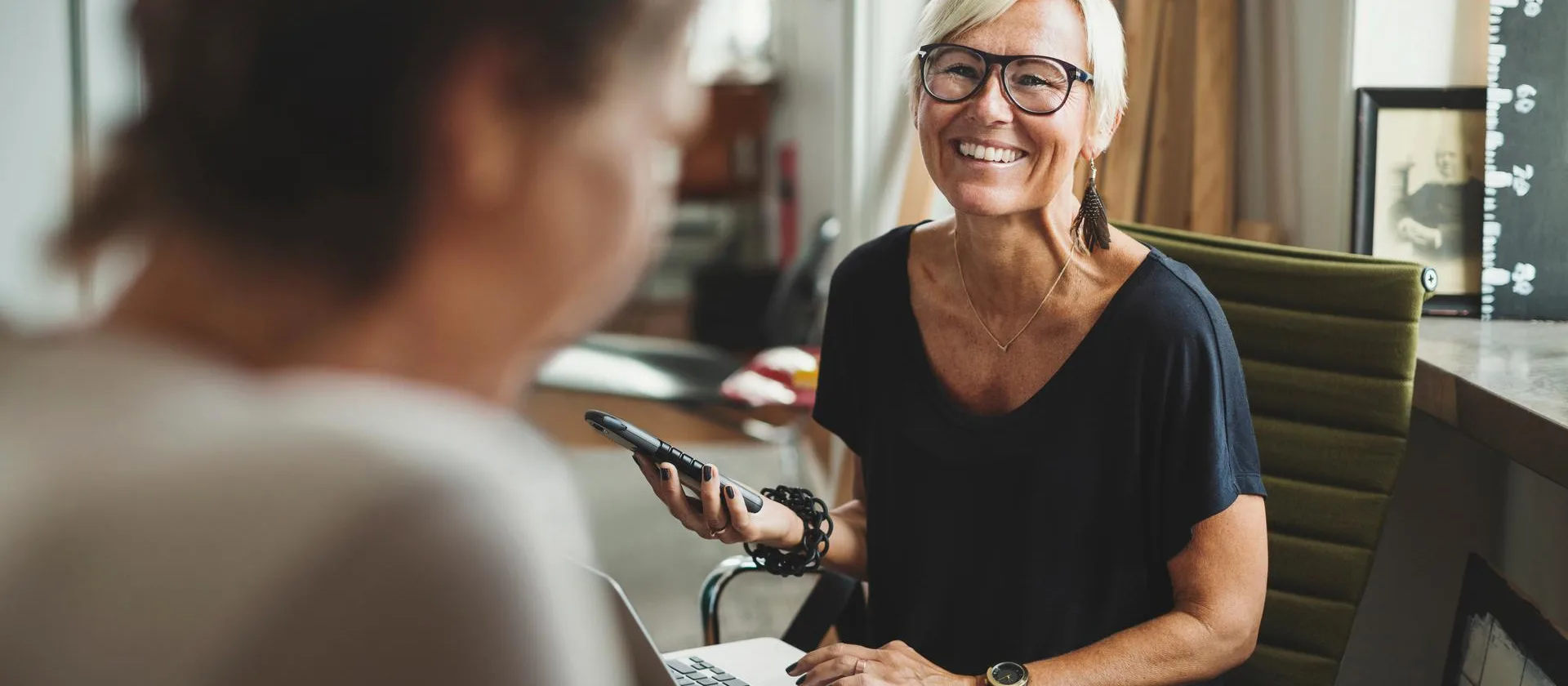 fröhliche Dame am Laptop im Austausch mit einer Person