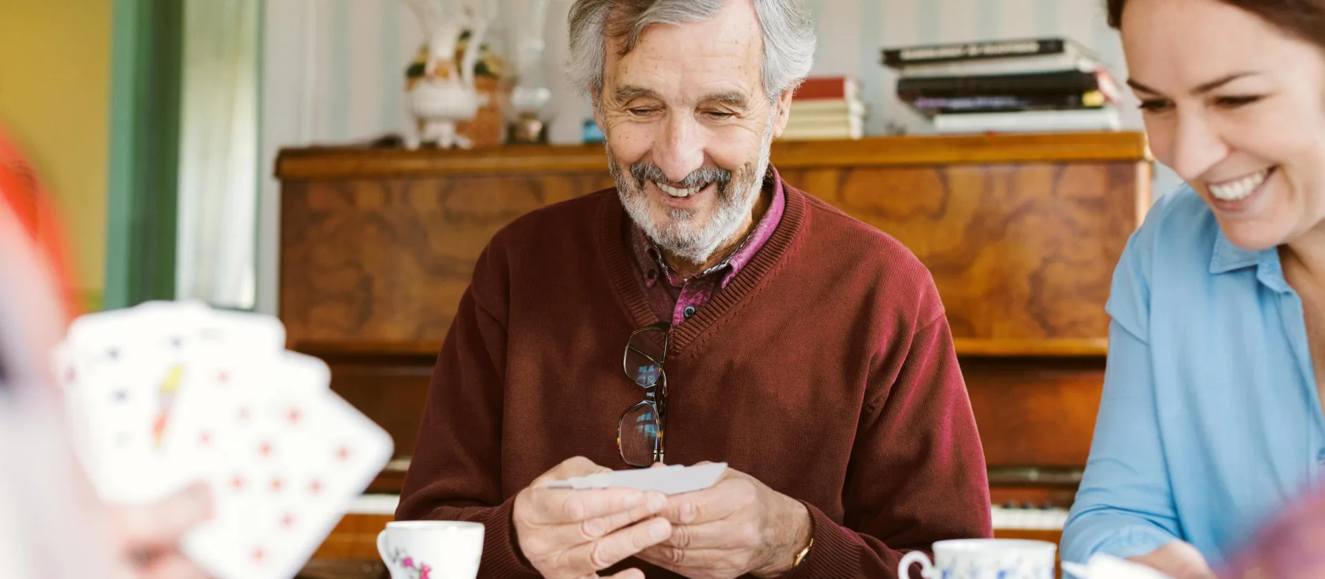 Senior mit seiner Familie am Karten spielen