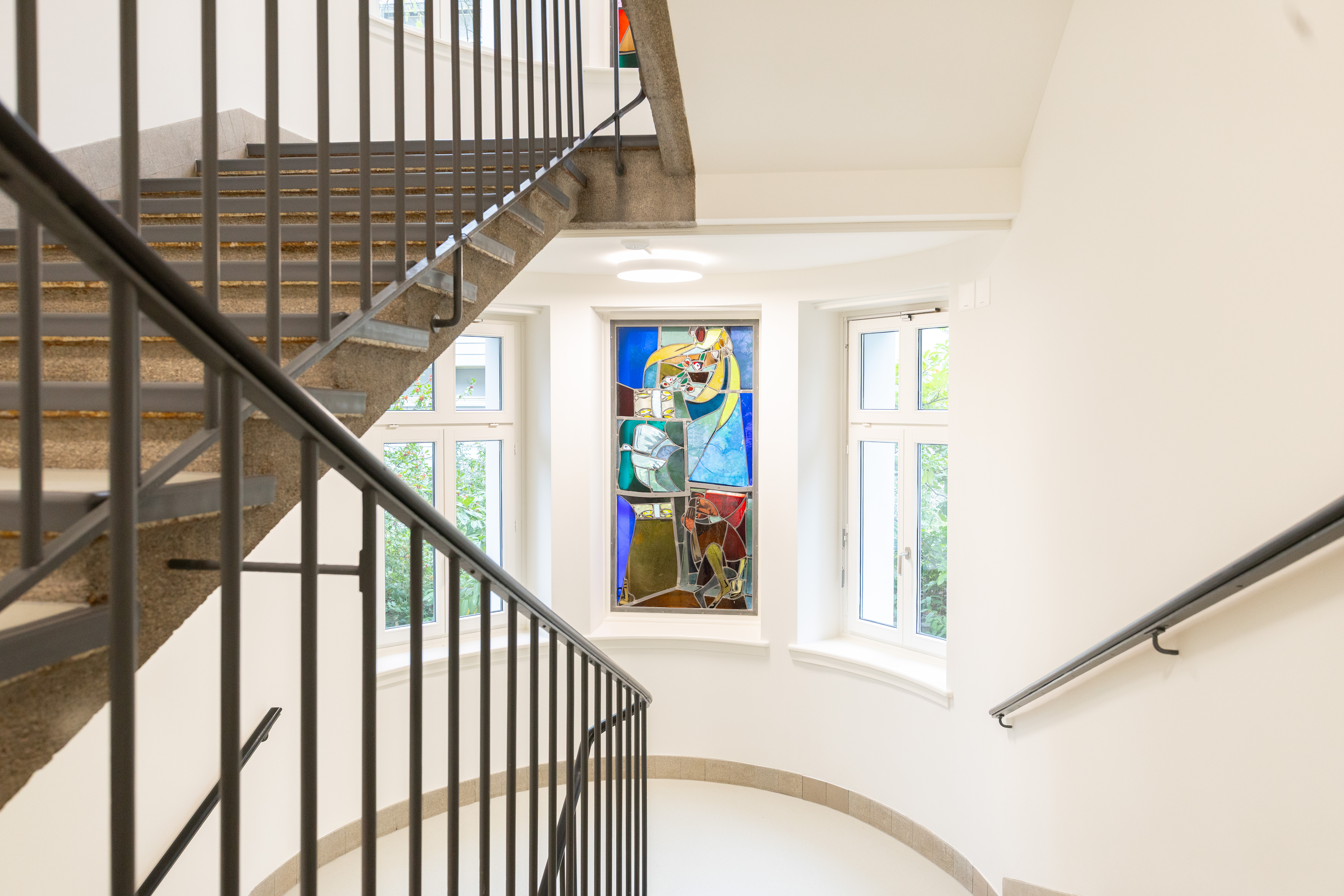 Wohnen im Socin Haus, frisch saniert und renoviert, helles Treppenhaus, farbiges Fensterglas